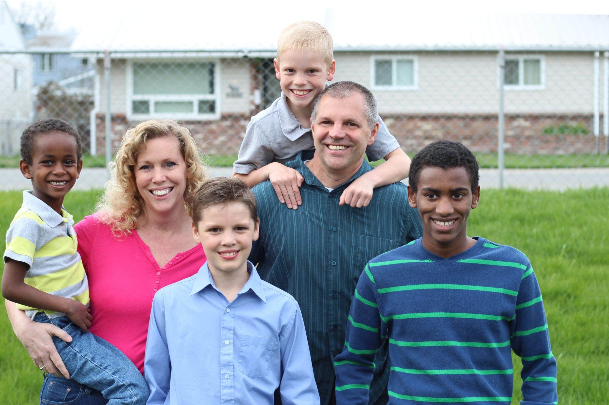 A multi-racial family, with the caucasian mother and father with their caucasian biological sons and their African adopted sons.